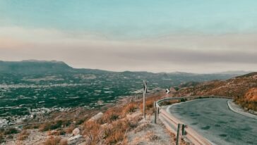 brown wooden fence on green grass field near body of water during daytime